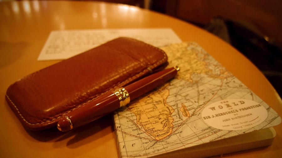 A travel diary on a map with a pen.